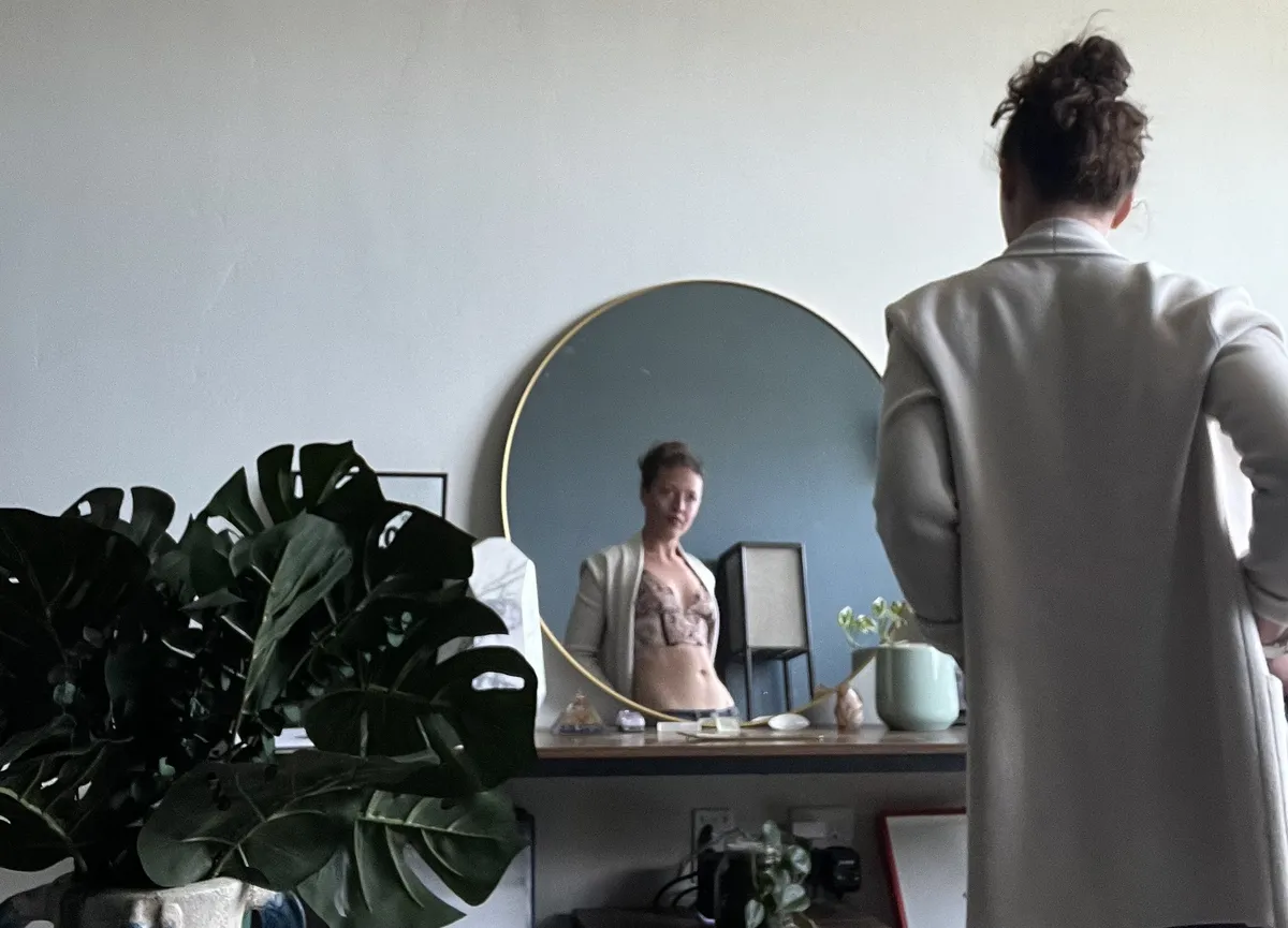 Destiny Cabrales standing in a bright room, reflected in a round mirror